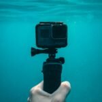 person holding action camera in underwater